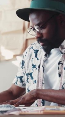 Özenle odaklanmış bir tasarımcı, modern bir stüdyo ortamında bir bantla kumaşı doğru ölçüyor.