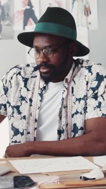 Kendini adamış ve odaklanmış bir moda tasarımcısı ilham dolu canlı bir stüdyoda yenilikçi tasarımlar çiziyor.