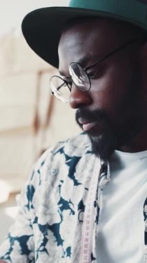 Şık gözlükler takan şık bir adam ve renkli çiçekli bir gömlek, düşüncelerine ve yansımalarına dalmış.