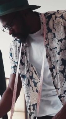 Yetenekli bir moda tasarımcısı, yaratıcı bir çalışma alanındaki çeşitli kumaşları titizlikle çizer ve ölçer.