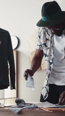 Fevkalade yetenekli bir moda tasarımcısı, şık bir çalışma alanında muhteşem tasarımlar çizer ve organize eder.