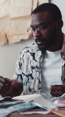 Farklı tekstil modelleri ve malzemeler konusunda yetenekli, şık ve ilham verici bir stüdyo ortamında odaklanmış bir tasarımcı.