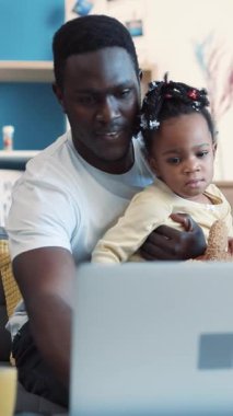 Kendini işine adamış ve sevecen bir baba kızıyla birlikte dizüstü bilgisayar kullanarak keyifli bir şekilde vakit geçiriyorlar.