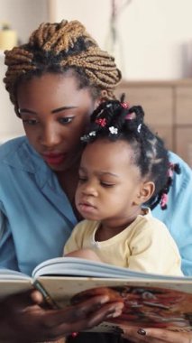 Bir annenin kızına kitap okuması, hayat boyu öğrenme ve hikayelere duyulan sevgiyi beslemesi.