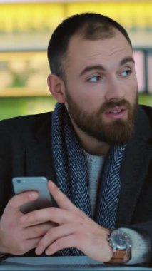 Kendini işine adamış ve odaklanmış bir iş adamı, modern iş yaşam tarzını örnek alarak akıllı telefonundan yararlanıyor.