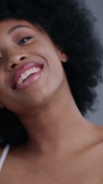 Afro saç stili, neşeli bir kadın. Sanatsal yüz makyajı ile süslenmiş, kendine güveni ve tarzı olan..