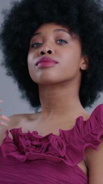 Doğal afro saçı ve şık bir elbisesi olan kendine güvenen bir kadının çarpıcı bir portresi..