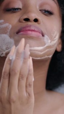 Genç bir kadın ferahlatıcı ve canlandırıcı bir yüz yıkama, kişisel bakım, cilt sağlığı ve sağlık hizmetlerinden hoşlanır.