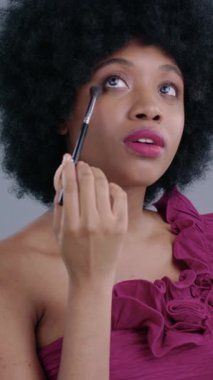 Şık ve sofistike bir ortamda şık bir kadın makyaj fırçasını kullanarak canlı renkler kullanır.