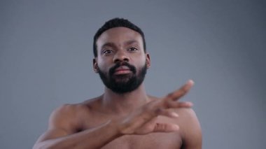 Bu portre, eşsiz özelliklerini vurgulayan ve minimalist bir ortamda bakımlı sakal bırakan bir adamı yakalıyor.