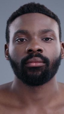 Düşünceli bir şekilde aşağı bakarken kısa, desenli saçları olan bir adamı gösteren yakın plan bir görüntü.