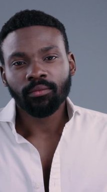 Beyaz bir gömlek giymiş düşünceli bir adam, yukarıdan zarif bir şekilde çekilmiş, iç gözlem ve zarafet saçıyor.