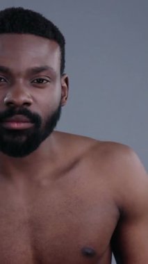 Çok düşünceli bir an, sakin bir stüdyo ortamında doğal saçı olan bir adamın güzel bir şekilde görüntülenir.