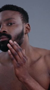 Genç bir adam, hem doğal güzelliğini hem de derin iç dünyasını yansıtırken, aşağıya doğru bakar.