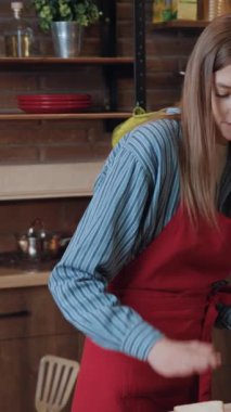 Birbirlerine aşık güzel genç bir çift mutfakta yemek pişiriyor ve yemek yiyorlar. Gülümseyen bir kadının portresi sandviç pişiriyor ve evde kocasını besliyor..