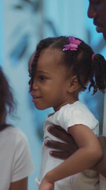 Sevgi dolu bir çift, sevimli küçük kızlarını pembe bir kurdeleyle kucaklıyor. O bir tek boynuzlu at ve oyuncak ayıyla oynarken onlar da mutlu anları paylaşıyorlar.