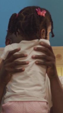 Bu video, aile bağlarını ve aile bağlarının neşesini gözler önüne seren bir adamla küçük bir kız arasındaki hassas anı yakalıyor.