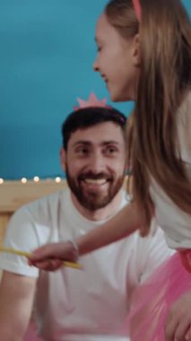 Tuhaf bir video pembe taç takmış sakallı bir adamın pembe etekli bir kızla eğlendiğini, gülümsediğini ve güldüğünü gösteriyor.