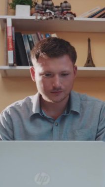 Bir adam, dizüstü bilgisayarına odaklanmış bir şekilde masada oturuyor. Video, sessiz ve modern bir çalışma alanındaki verimliliği ima ederek konsantrasyonunu gösteriyor.