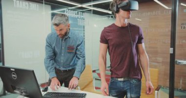 İki erkek sanal gerçeklik ortamında, bilgisayar üzerinde işbirliği yapıyor ve onların deneyimlerini tartışıyor, takım çalışmalarını ve yeniliklerini ön plana çıkarıyor.