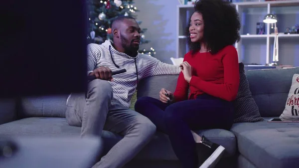 Yakışıklı adam Noel ağacının arka planında dikkatlice kız arkadaşını dinliyor. Genç ve güzel bir kadın konuşuyor ve el kol hareketi yapıyor. Gülümsüyor. Kapalı.