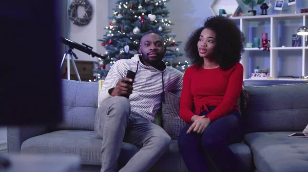 Koltukta oturan iki kişilik genç Afrikalı bir aile. Kırmızı kazaklı genç kıvırcık kadın bir şey söylüyor. Kutlama atmosferi.