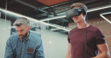 Bu videoda, iki adam sanal gerçekliği keşfediyor. Bir tanesi arkadaşı izlerken bir VR kulaklığı kullanıyor. Üçüncü bir birey Dell bilgisayarında modern teknolojiyi harmanlıyor.