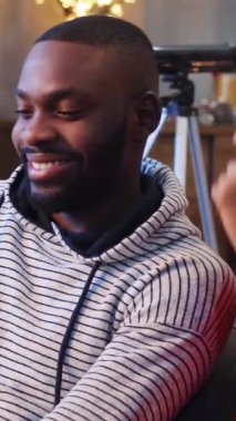 NEW YORK - 13 Aralık, 2017. Elinde pembe dijital tablet tutan yakışıklı bir adam. Ekrana bakan kıvırcık saçlı güzel bir Afrikalı kadın. Kapalı alanda gülümsüyor.