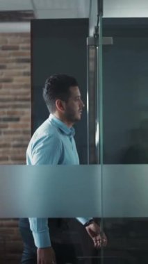 Genç ve çekici bir adam modern ofisteki salona gider. İş merkezi. İş için. Çalış. - Evet. RED Epic Camera 'da Çekim.