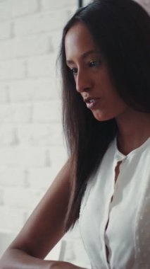 Genç, güzel bir mulatta kadın bilgisayarın başında oturmuş görüntülü konuşma yapıyor. Evde, mutfakta. Mutlu hissettiriyor. Çubuklar. Modern tasarım. RED Epic Camera 'da Çekim.