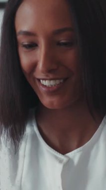 Bilgisayarın başında oturup görüntülü konuşma yapan genç, güzel mulatta kadını kapat. Evde, mutfakta. Mutlu hissettiriyor. Çubuklar. Modern tasarım. RED Epic Camera 'da Çekim.