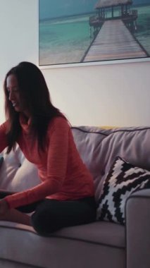 Genç ve güzel bir mulatta kızı dizüstü bilgisayarda çalışıyor telefonu alıyor ve gidiyor. - Evde. Mutlu hissettiriyor. Çağdaş tasarım. RED Epic Camera 'da Çekim.