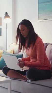 Genç ve güzel bir kız dizüstü bilgisayarda çalışır telefonu alır ve gider. - Evde. Mutlu hissettiriyor. Çağdaş tasarım. RED Epic Camera 'da Çekim.