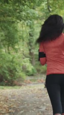 Parkta koşan genç mulatta kadın. Arkadan çerçevele. RED Epic Camera 'da Çekim.