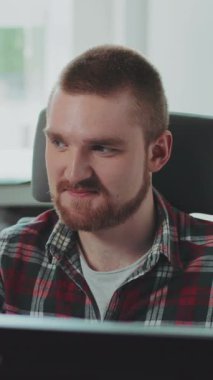 Genç sakallı bir adam bilgisayarın başında oturuyor. Ofiste çalışıyor. Mutlu hissettiriyor. Çağdaş tasarım. RED Epic Camera 'da Çekim.