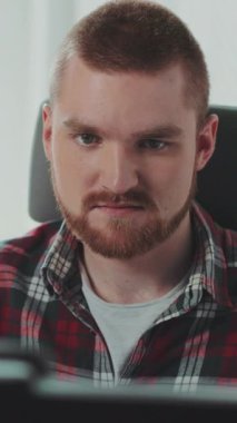 Genç sakallı bir adam bilgisayarın başında oturuyor. Ofiste çalışıyor. Mutlu hissettiriyor. Çağdaş tasarım. RED Epic Camera 'da Çekim.