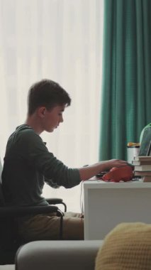 Genç, sınıftaki bir dizüstü bilgisayarla oturuyor. Çağdaş tasarım. RED Epic Camera 'da Çekim.