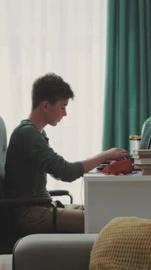 Genç sınıfta dizüstü bilgisayar kullanarak oturuyor, klavyedeki baskılar ev ödevlerini internetten mesajlaşarak sohbet etmeyi öğreniyor çağdaş tasarım. RED Epic Camera 'da Çekim.