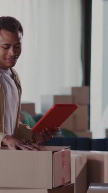 Evli bir çift Afrikalı genç kadın ve adam taşınmaya hazırlanıyor. Evlerinde mobilya ve karton kutular var..