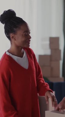 Bir çift neşeli Afro-Amerikalı erkek ve kadın taşınmak için eşyalarını topluyorlar birbirlerine sarılıyorlar ve hayatlarının olayını kutluyorlar. Aileler. Çıkıyorum..