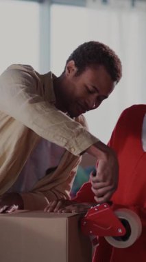 Afrikalı Genç Aile Taşınma Evi. Kız Arkadaşla Mutlu Yardım Kutuları Giysilerle Kutu Paketleme Yapıştırıcı Bant Taşıma Hazırlama.