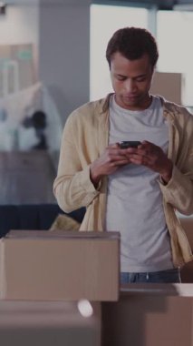 Genç Afrikalı sıradan bir adam taşınma hazırlıklarını bitiriyor, cep telefonuyla arıyor ve nakliye için taksi çağırıyor..