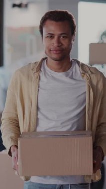 Neşeli Afrikalı Genç Adam Portresi Mobilya ve Kıyafetlerle Kutuları Topluyor Kamera Taşıma Evi İçin Gülümsüyor.