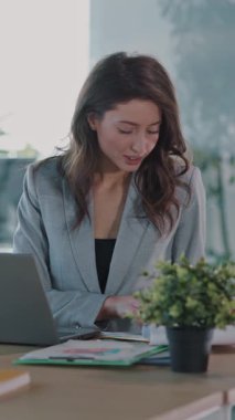 Profesyonel bir kadın şık ofis masasında iyi tasarlanmış, modern bir ortamda üretken bir iş yapmaktadır.