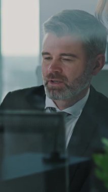 Odaklanmış bir işadamı, üretkenliği artırmak ve hedeflere ulaşmak için modern bir ofisteki bilgisayarda önemli verileri gözden geçirir.