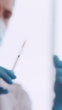 Kafkasyalı genç doktor, Kafkas kadın hastasına özel klinik hastanesinde aşı enjekte ediyor. Karantina.
