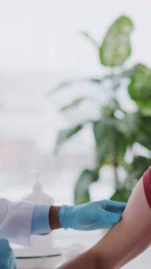 Beyaz önlüklü Afro-Amerikalı doktor Coronavirus enfeksiyonuna karşı aşı deneyi yapıyor. Yüz maskeleri. Salgın.