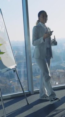 Afro-Amerikalı hoş iş kadınının dikey çekimi. Ekonomi semineri veriyor. Grafik kurulu iş arkadaşlarıyla toplantıda iletişim kuruyor..