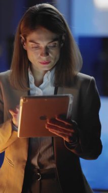 Kendini işine adamış profesyonel bir kadın tabletini çağdaş ve modern bir ofis ortamında kullanıyor.