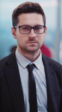 Resmi bir takım elbise ve şık bir kravat takmış seçkin bir adam da burnunun üstüne şık bir gözlük takıyor.